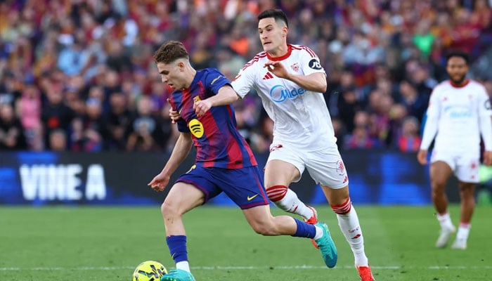 FC Barcelonas Fermin Lopez in action with Sevillas Andres Castrin. —Reuters/File