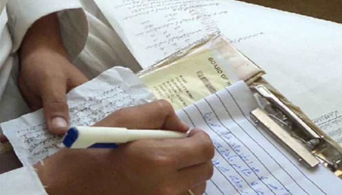 The representational image shows a student using unfair means in an unspecified examination. — The News/File