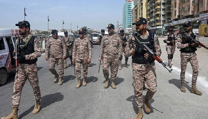 Security personnel patrol along a street in Karachi on April 1, 2024. — AFP
