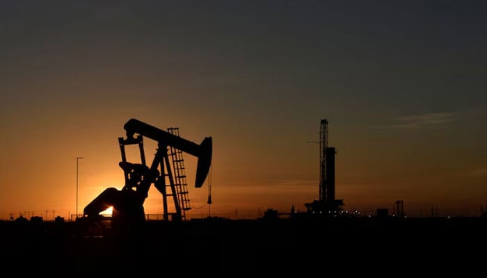 The representational image shows a pump jack operating in front of a drilling rig at sunset in an oil field in Midland, Texas US August 22, 2018. — Reuters