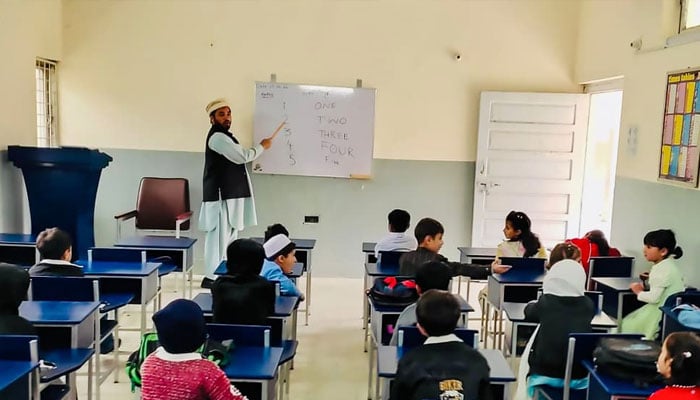 A teacher taking class in a primary school at Golen Gol Hydel Power Stations Colony in Koghuzi village in Chitral, established by WAPDA. —WAPDA website/File
