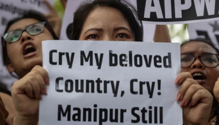 Protesters hold placards as they attend a protest against the alleged sexual assault of two tribal women in Manipur, in New Delhi.—Reuters