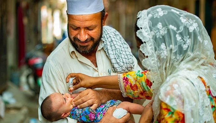 A baby is receiving polio vaccination drops in Maraghzar Colony, Lahore. — WHO/File