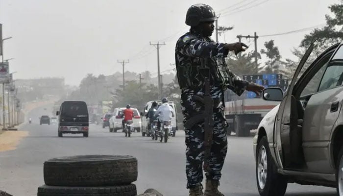 A police officer stops a car at a check point to check the activities of criminals and unknown gunmen ahead of the February 25 presidential election at Awka in Anambra State, southeast Nigeria, on February 16, 2023.—AFP/File