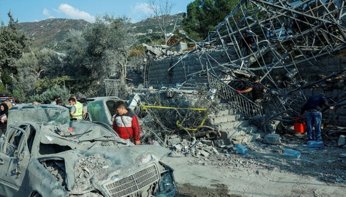 A person looks at a destroyed vehicle, at a site of an Israeli strike, in the town of Almat in Jbeil district, Lebanon November 10, 2024. —Reuters