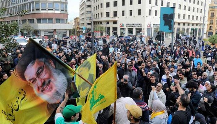 Hezbollah supporters wave a flag bearing a portrait of slain Hezbollah leader Hassan Nasrallah as they stage an anti-government protest outside the Lebanese governmental palace in Beirut on Apr. 9, 2026. —AFP