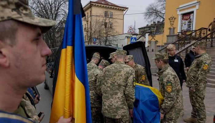 Ukrainian soldiers unloading the bodies from an ambulance received from Russia. —AFP/File