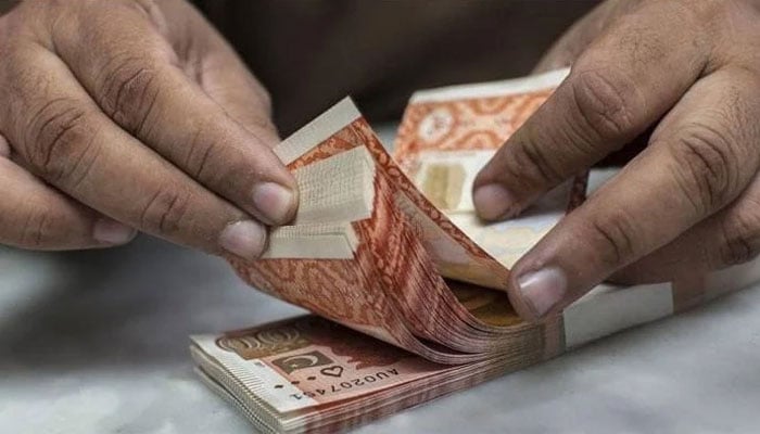 A money exchange broker is seen counting Pakistani Rs5,000 banknotes. — Reuters/File