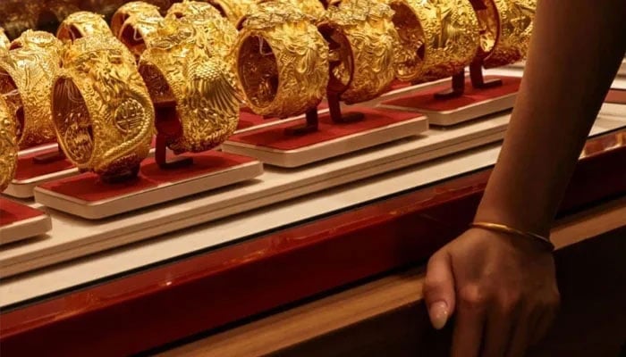 A customer looks at gold bracelets inside a jewellery store, in Hong Kong, China, February 4, 2026. — Reuters