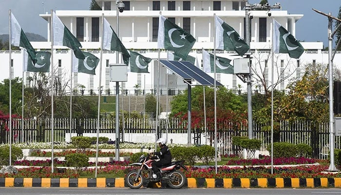 A man rides a motorcycle past the President house as Pakistan gears up to host the US and Iran for peace talks, in Islamabad, on April 9, 2026. — Reuters