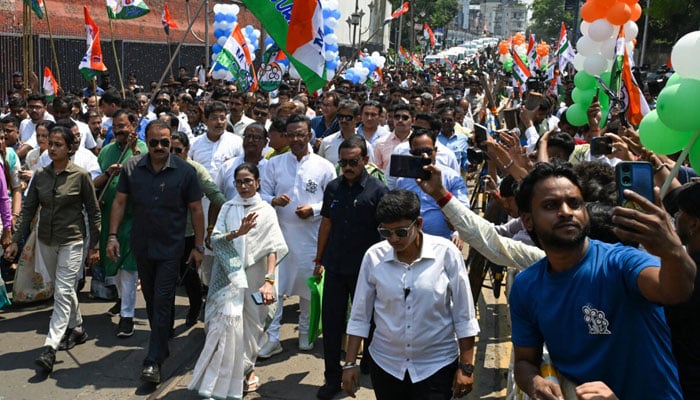 Chief Minister of West Bengal and Chairperson of All India Trinamool Congress, Mamata Banerjee, greets supporters as she arrives to file her nomination papers on April 8. — AFP