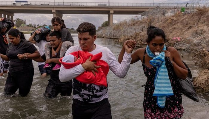 Yusniel, a migrant from Cuba, holds his 10-day-old son, Yireht, and wife, Yanara, as they search for an entry point past a wire fence along the bank of the Rio Grande river after wading into the United States from Mexico in Eagle Pass, Texas, US October 6, 2023. — Reuters