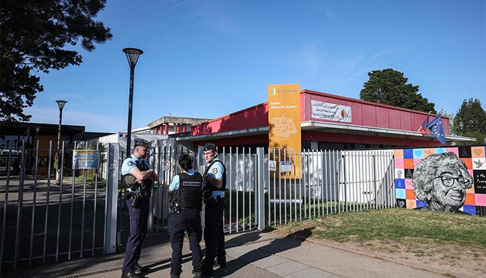 Gendarmes stand outside the Lycee Polyvalent Joubert - Emilien Maillard secondary school where a teenage girl was attacked with a knife by another student on the premises in Ancenis-Saint-Gereon, western France, on April 10, 2026. — AFP