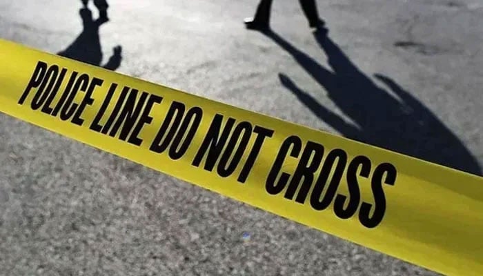 This representational image shows police officers standing behind the crime scene police tape. — AFP/File