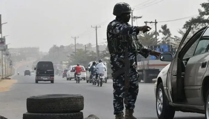 A police officer stops a car at a check point to check the activities of criminals and unknown gunmen ahead of the February 25 presidential election at Awka in Anambra State, southeast Nigeria, on February 16, 2023.—AFP/File