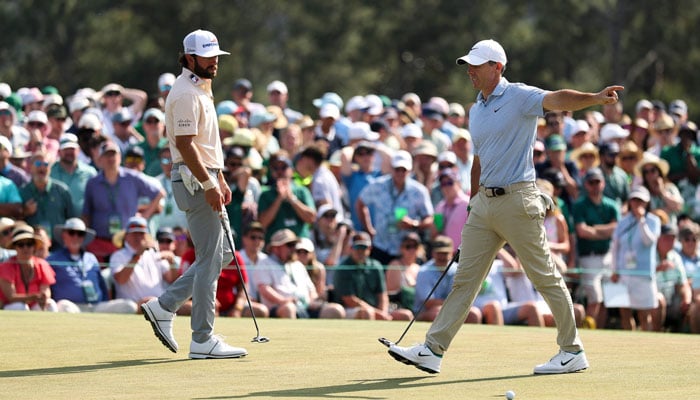 Rory McIlroy of Northern Ireland reacts on the ninth green as Cameron Young of the United States looks on during the final round of the 2026 Masters Tournament at Augusta National Golf Club on April 12, 2026 in Augusta, Georgia. — AFP