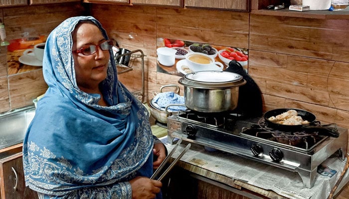 This representational image shows a woman prepares lunch for her son in Karachi. — AFP/File