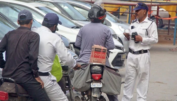 A representational image showing traffic police personnel interacting with motorists in Karachi on March 19, 2024. — Online