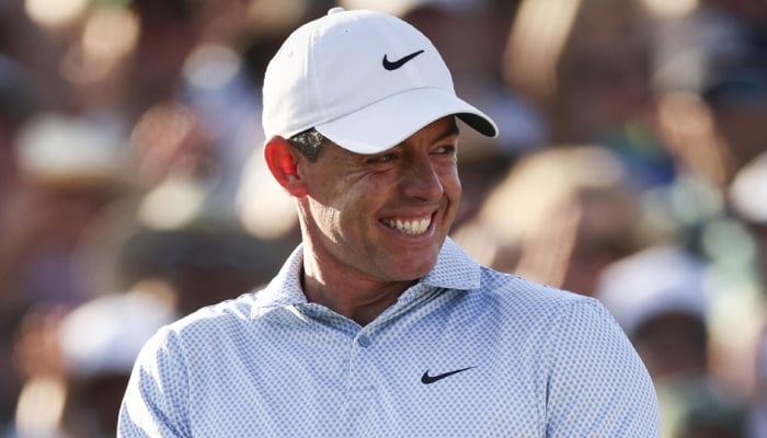 Rory McIlroy celebrates on the 18th green after winning his second consecutive Masters title and sixth career major crown. —AFP