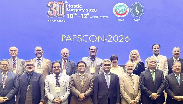 The image shows a group photo during the 30th Annual International Conference of the Pakistan Association of Plastic Surgeons (PAPS) on April 12, 2026. — Facebook@drshahzadhsa