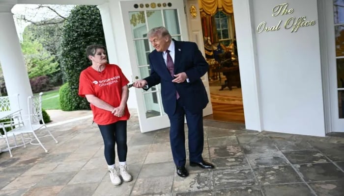 US President Donald Trump tips Doordash delivery worker Sharon Simmons after she delivered Mcdonald’s outside of the Oval Office at the White House, in Washington, DC, on April 13, 2026. —AFP