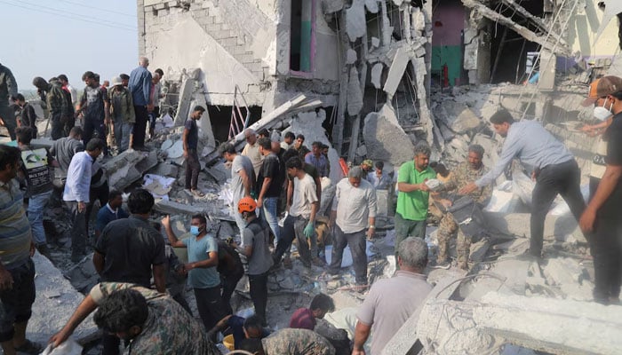 People and rescue forces work following a reported strike on a school in Minab, Iran, February 28, 2026. — Reuters