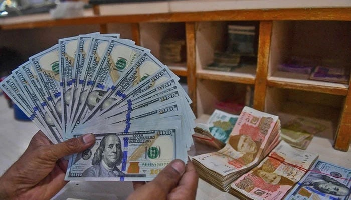 A foreign currency dealer counts US dollars at a shop in Karachi, Pakistan, on May 19, 2022. — AFP/File