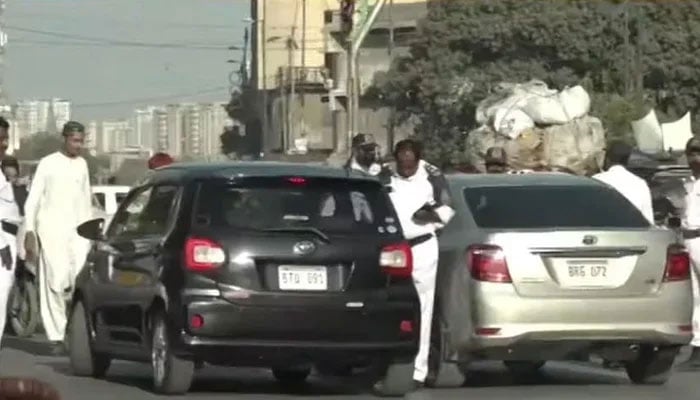 The representational image shows traffic personnel issuing challans to citizens in Karachi. — Geo News/File