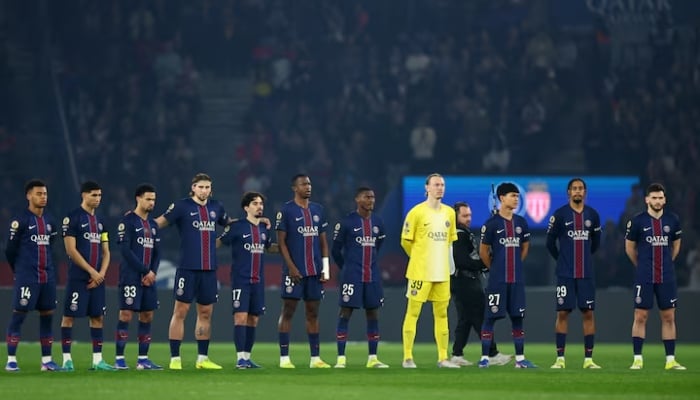 Paris St Germain players line up during a minute silence for the late Jack Jacquet before the start of the match. —Reuters