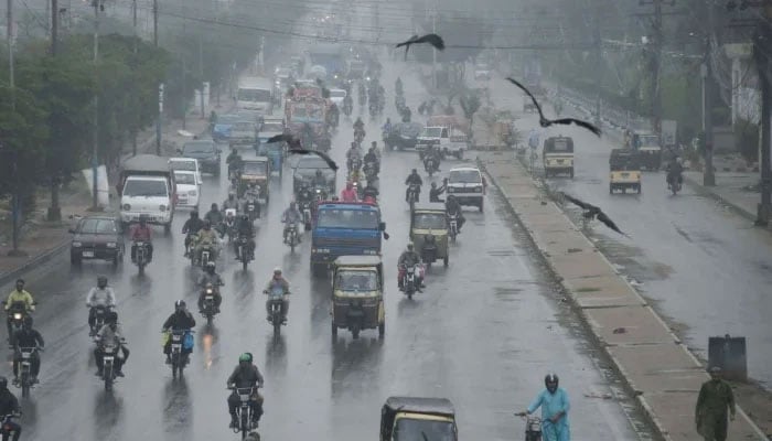 Commuters are passing through a road during the downpour of the monsoon in Karachi on August 23, 2025. — Online