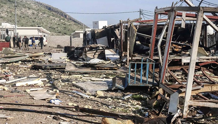 Komala party members look towards the debris is strewn from mangled structures following drone strikes on the Iranian Kurdish opposition Komala partys Sordash camp, which resulted in the death of a female party member and the injury of two others, some 40 km northwest of the city of Sulaymaniyah in the autonomous Kurdistan region on April 15, 2026. — AFP