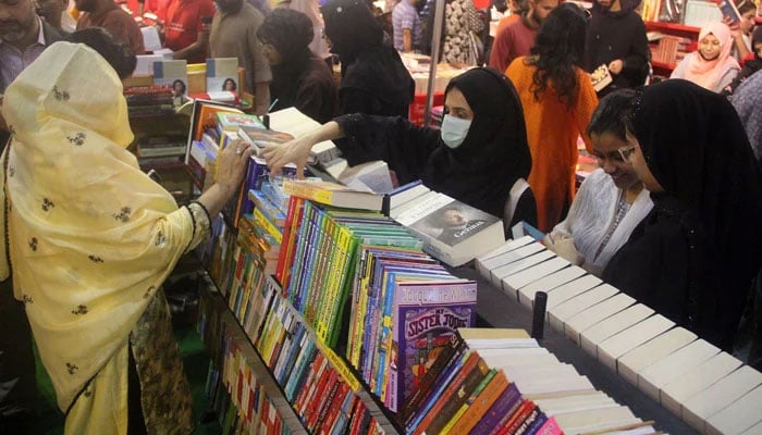 People are busy buying books on book stalls during a book fair at the Expo Centre in Karachi on December 17, 2023. — Online
