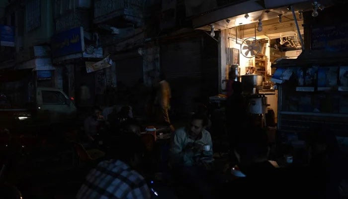 People at a local cafe during a power outage. — AFP/File