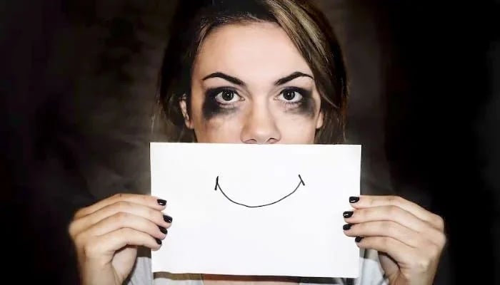 The representational image shows a woman depicting how depression is hidden with a false smile. — Unsplash/File