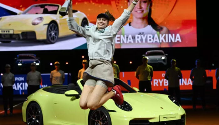 Kazakhstans Elena Rybakina jumps with the trophy in front of the winner’s car after winning the WTA Stuttgart tournament on clay in Germany. — AFP