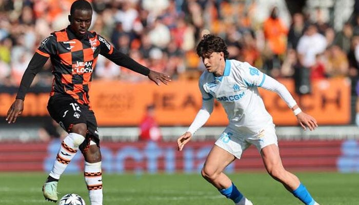 Lorient’s Senegalese forward Bamba Dieng fights for the ball with Marseille’s Argentinian defender Leonardo Balerdi during their French L1 match at the Moustoir stadium in Lorient, western France on April 18, 2026. — AFP