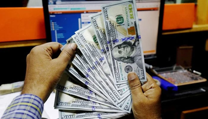 A trader shows US dollar notes at a currency exchange booth in Karachi, on December 3, 2018. — Reuters