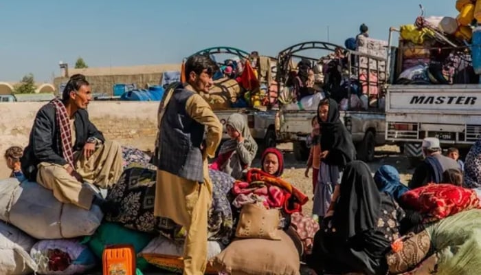 A Chitral family with belongings waiting for vehicle to return to their home. —Chitral Today/File