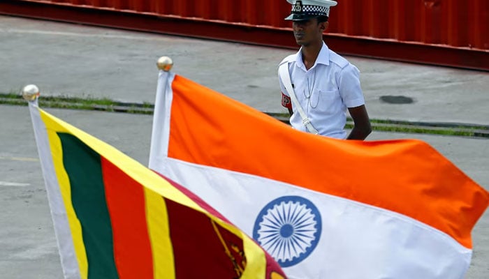 A Navy officer stands in front of Indias and Sri Lankas national flags. — Reuters/File