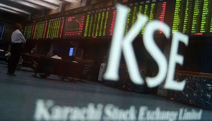 In this undated photo, Pakistani stockbrokers watch the latest share prices on a digital board during a trading session at the Karachi Stock Exchange (KSE). — AFP/File