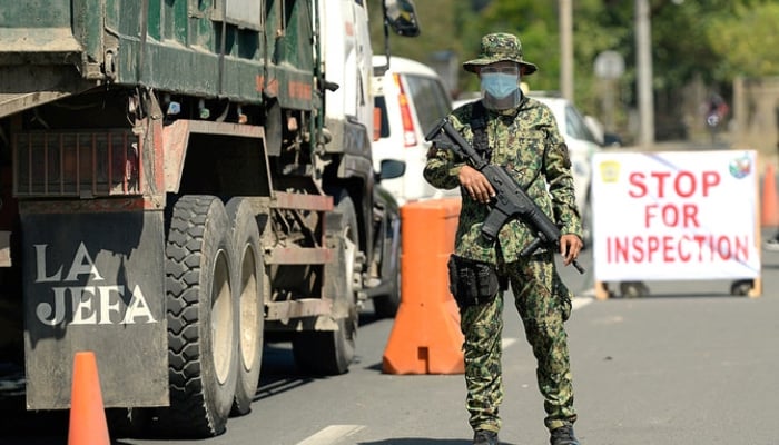A Filipino police officer stands alert at a checkpoint. —Reuters/File