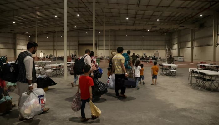 Special Immigrants from Afghanistan walk through the in-processing building after their evacuation at Camp As Sayliyah, Qatar, August 20, 2021.—Reuters