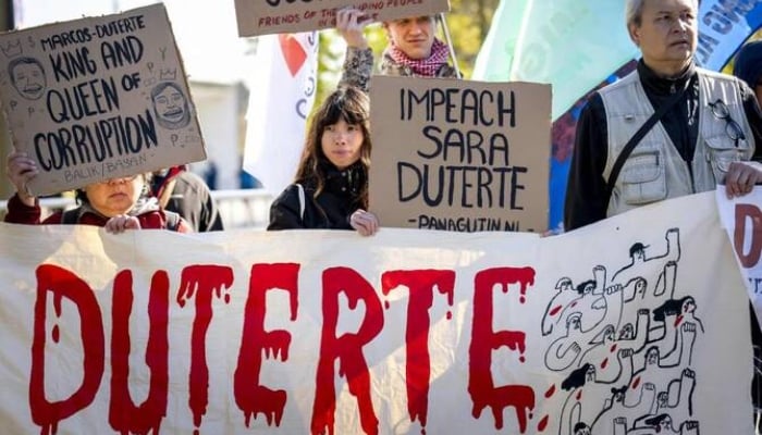 Protesters hold placards in front of the International Criminal Court (ICC) ahead of the ruling on the appeal by the former Philippines President Rodrigo Duterte. —AFP
