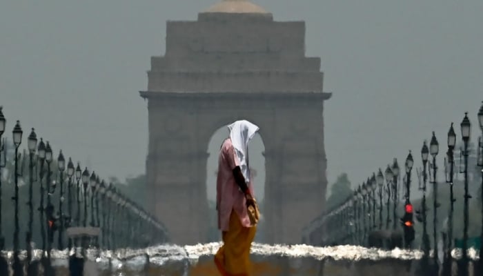 A woman walks past India Gate in New Delhi in June 2025. —AFP/File