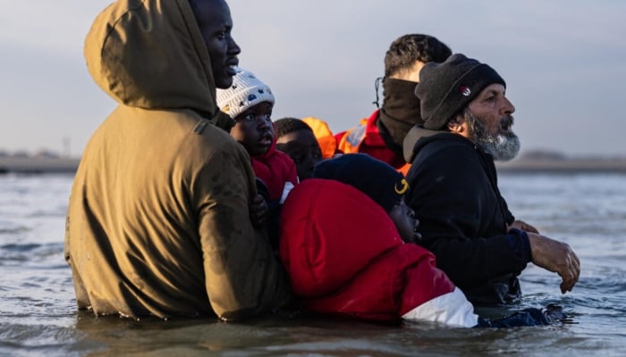 Migrants try to board a smugglers boat in an attempt to cross the English Channel off the beach of Gravelines, northern France, on March 3, 2026. —AFP