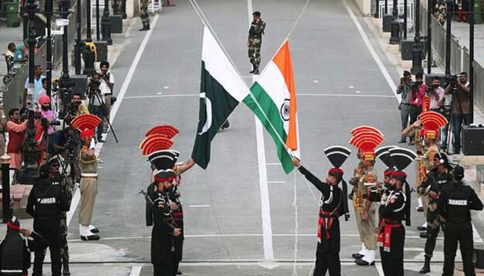Pakistani Rangers (wearing black uniforms) and Indian Border Security Force (BSF) officers lower their national flags during parade at the Pakistan-India joint check-post at Wagah border. — Reuters/File