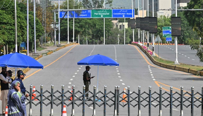 Security personnel stands guard at a closed road leading to the Serena Hotel in the Red Zone area of Islamabad on April 23, 2026. — AFP