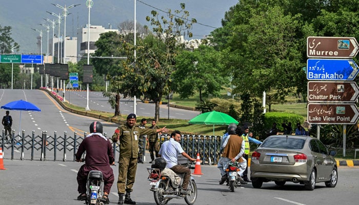 A security personnel manages traffic at a closed road leading to the Serena Hotel in the Red Zone area of Islamabad on April 23, 2026. — AFP