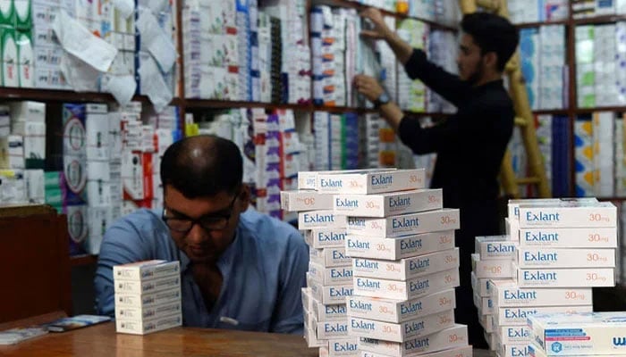 Pharmacists arrange medicines at a pharmacy shop. — AFP/File