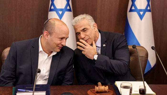 Israels caretaker Prime Minister Yair Lapid speaks with former prime minister Naftali Bennett during the weekly cabinet meeting in Jerusalem, September 18, 2022. — Reuters